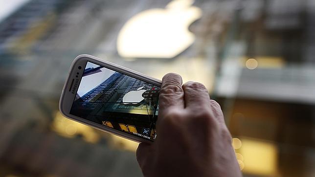 Un usuario de un teléfono de Samsung toma una fotografía del logo de Apple