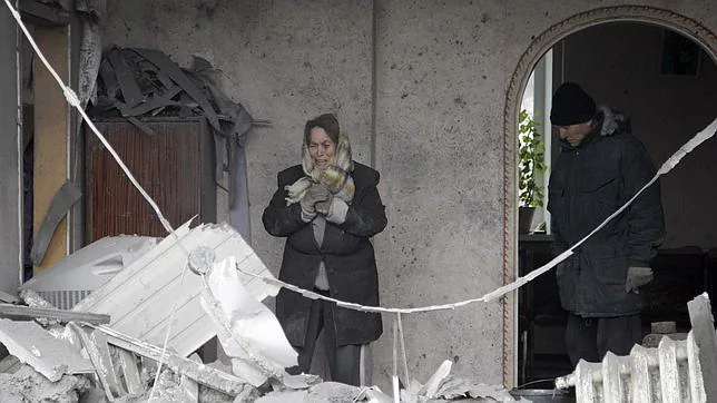 Una mujer llora ante su casa destrozada por las bombas en un suburbio de Donetsk (este de Ucrania)