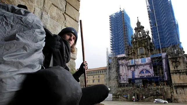 Un peregrino ante la fachada de la Catedral en la plaza del Obradoiro