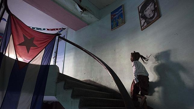 Una niña pasa en La Habana junto a una imagen del Che Guevara