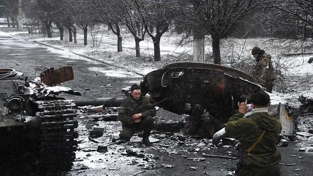 Separatistas prorrusos se toman fotos junto a un taque destruido del Ejército de Ucrania en Uglegorsk
