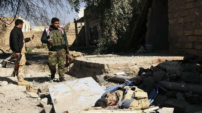 Militares kurdos junto al cadáver de un miembro del Estado Islámico cerca de Mosul (Irak)