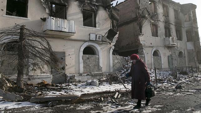 Una mujer camina delante de un edificio en pueblo cercano a Donetsk