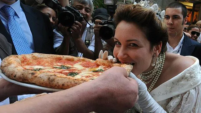 Una actriz que representa a la reina Margarita de Saboya degusta la famosa pizza que lleva su nombre