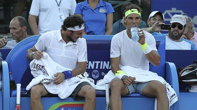 El argentino Juan Mónaco y Rafael Nadal descansan durante su partido de dobles