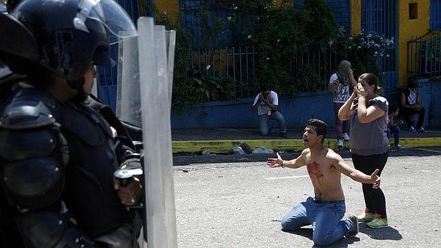 Un joven con el pecho manchado de sangre, frente a la Policía, tras la muerte de Kluiver Roa en una protesta en San Cristóbal (Táchira)