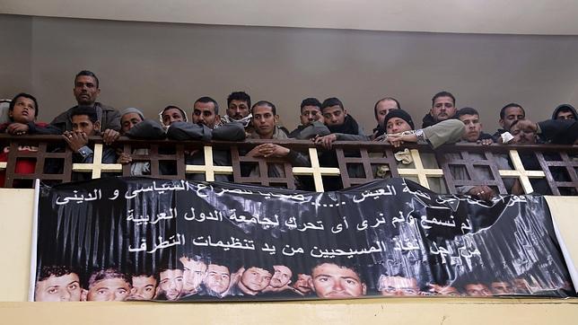Familiares de los coptos asesinados en Libia junto a los rostros de los muertos