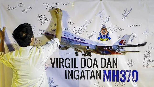 Un hombre escribe este viernes un mensaje durante un acto en recuerdo de las víctimas del vuelo MH370