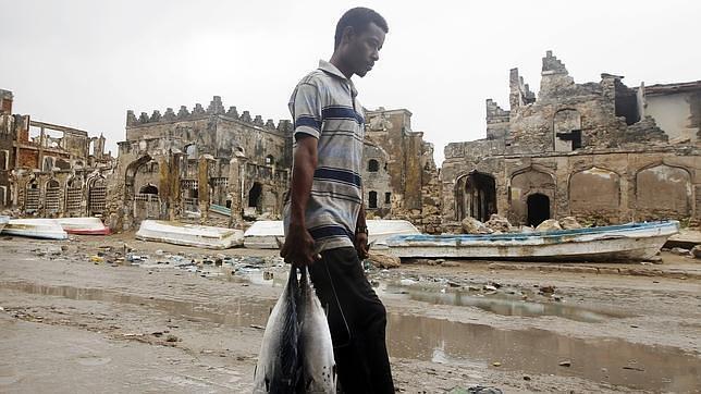 Un hombre con pescado por una calle de Mogadiscio en una fotografía de junio de 2012