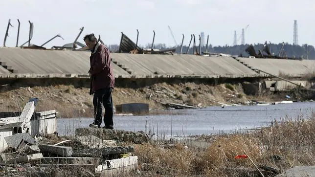 Un hombre observa los cimientos derruídos de una casa en los alrededores de la central nuclear de Fukushima