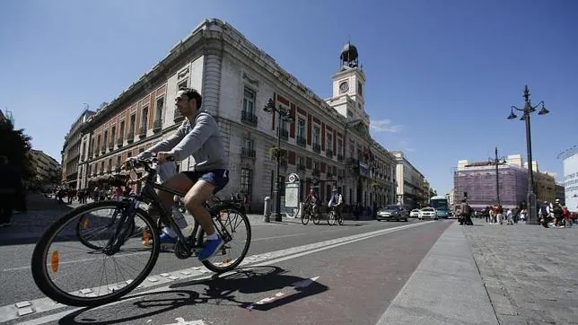 Un ciclista circula por el carril bici que atraviesa la Puerta del Sol