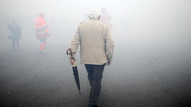 Un hombre cruza el denso humo producido por la mascletà de este miércoles