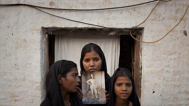 Las hijas de Asia Bibi, con un retrato de su madre junto a su casa en el Punjab paquistaní