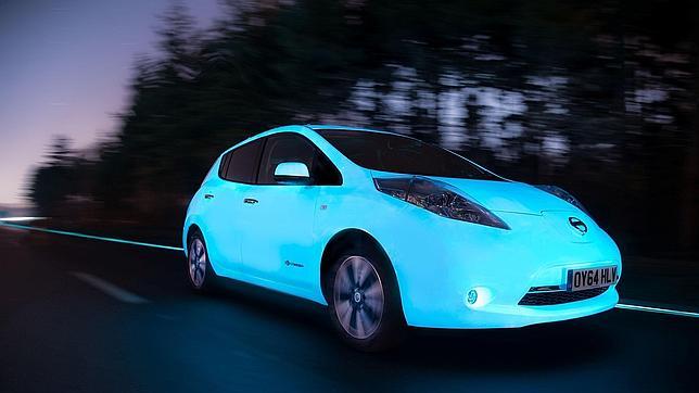 El coche que brilla de noche circula por una autopista autoiluminada