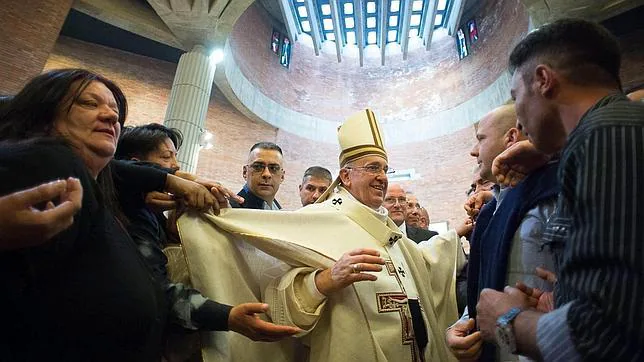 Algunos fieles tiran de la casulla del papa durante el tradicional lavado de pies de reclusos en Roma