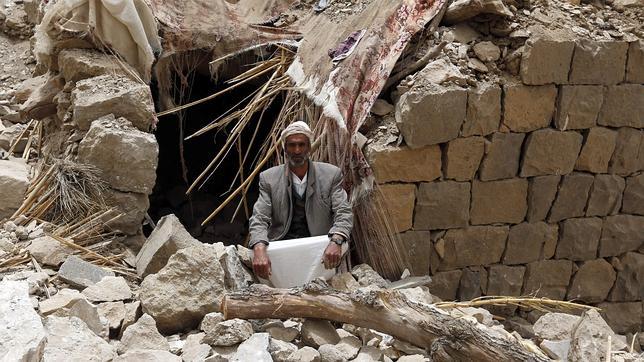 Un yemení sentado delante de su casa, completamente destrozada por un bombardeo aéreo de la coalición liderada por Arabia Saudí contra las posiciones hutíes en la ciudad de Hajer Akash, Sanaía, Yemen