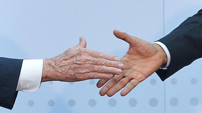 Barack Obama (d) y Raúl Castro (i), a punto de estrechar sus manos en Panamá