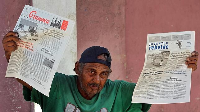 Un vendedor muestra los diarios oficiales Granma y Juventud Rebelde hoy, miércoles 15 de abril de 2015, en una calle de La Habana (Cuba)