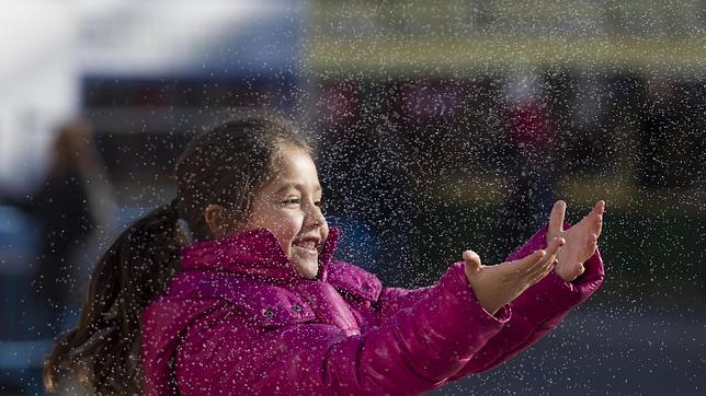Un niña juega con la nieve