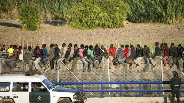 Un grupo de inmigrantes en la valla de Melilla