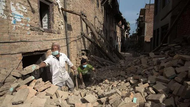 Dos hombres retiran escombros de una de las zonas afectadas por el seísmo