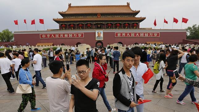 Varios turistas visitan la plaza de Tiananmen en Pekín (China)