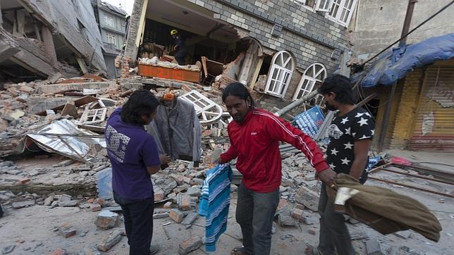 Varias personas recogen lo que queda de sus pertenencias de entre los emcombros causados el terremoto en Katmandú, Nepal