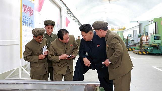 Kim Jong-Un charlando con miembros del partido en una fábrica norcoreana