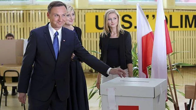 El presidente electo de Polonia, Andrej Duda, en el momento de votar en Varsovia junto a su mujer y su hija