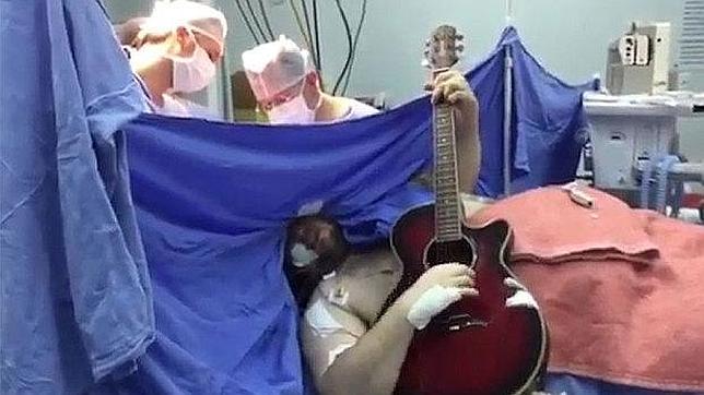 Un hombre toca la guitarra mientras le operan el cerebro