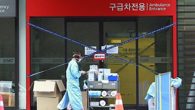 Un miembro de un equipo médico camina frente a una sala de urgencias cerrada, en el hospital Samsung de Seúl