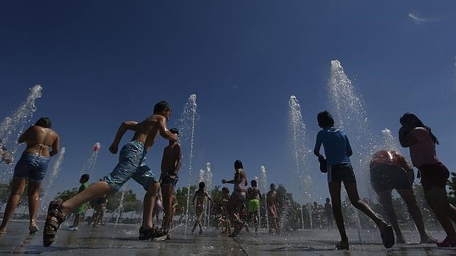 Unos niños juegan en verano en el parque Juan Carlos I