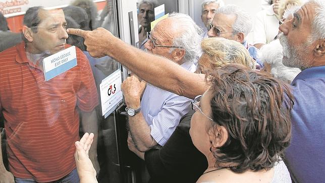 Jubilados esperan ayer a la puerta de un banco de Atenas para cobrar su pensión
