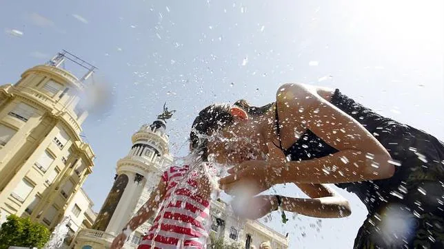 Una mujer se moja el rostro debido a la ola de calor en España