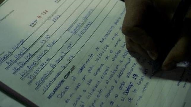 Un viajero rellena una hoja de reclamaciones