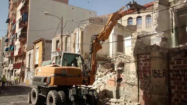 Una excavadora llevando a cabo el derribo en la calle Valencia