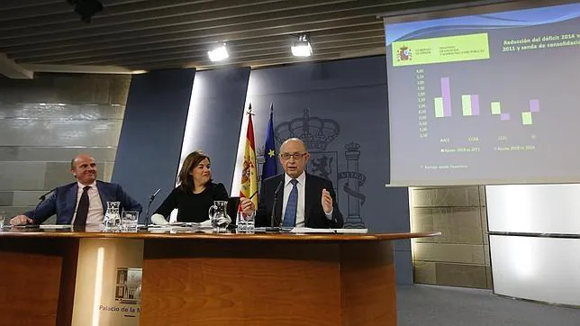 Luis De Guindos, Soraya Sáenz de Santamaría y Cristóbal Montoro, en rueda de prensa en la Moncloa