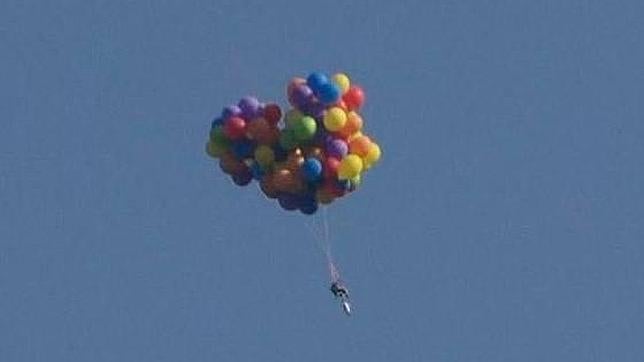 Un hombre en Canadá sobrevuela un estadio en una silla con globos de helio