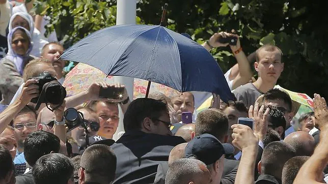 Aleksandar Vucic es protegido con un paraguas tras el lanzamiento de piedras