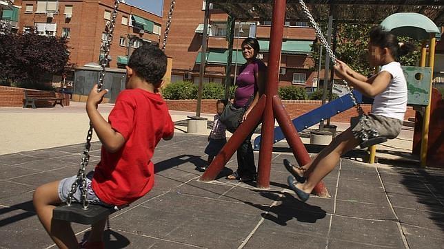 Varios niños juegan se divierten en un parque con columpios