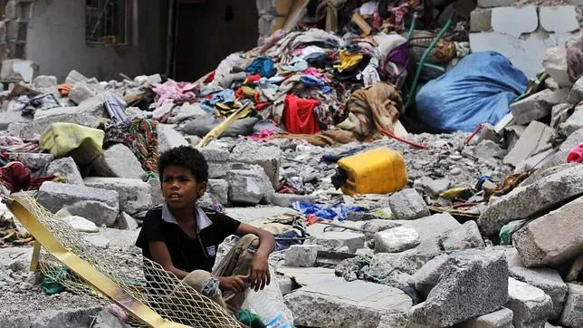 Un niño sentado entre los escombros de lo que fue su casa después de un bombardeo en Saná