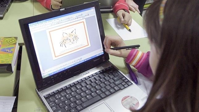 Un alumno trastea con una pizarra digital