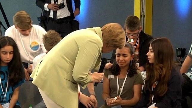 Angela Merkel intenta animar a una desconsolada niña