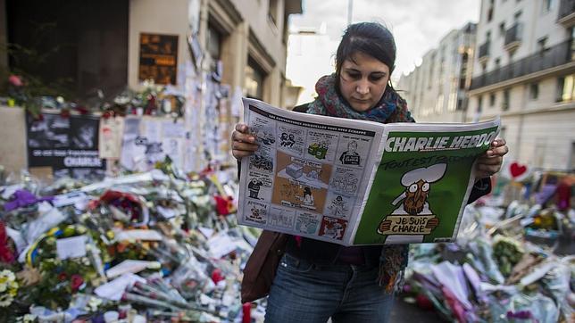 Una mujer con el semanario satírico Charlie Hebdo que se publicó tras el ataque el pasado enero