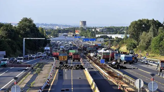 Ganaderos franceses bloquean con camiones y neumáticos una autopista en Limonest, cerca de la ciudad de Lyon (Francia)