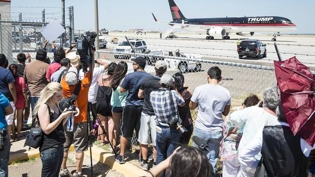 Periodistas y ciudadanos observan el avión con el que Donald Trump abandonó la frontera con México