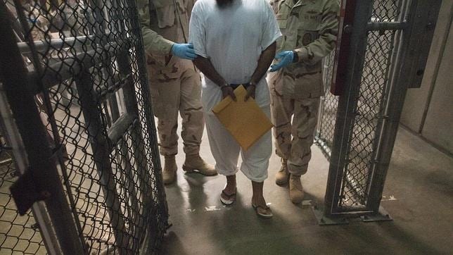 Dos guardas estadounidenses junto a un preso de Guantánamo en 2010