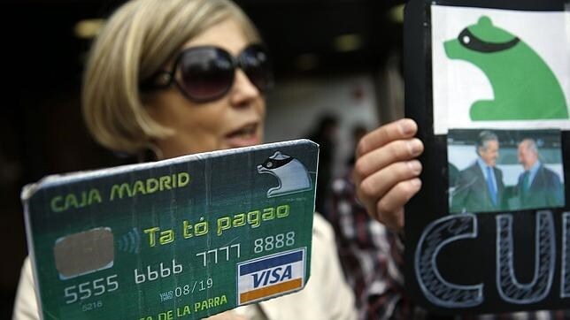 Manifestando mostrando una copia de una tarjeta de Caja Madrid en la que pone Ta To pagao