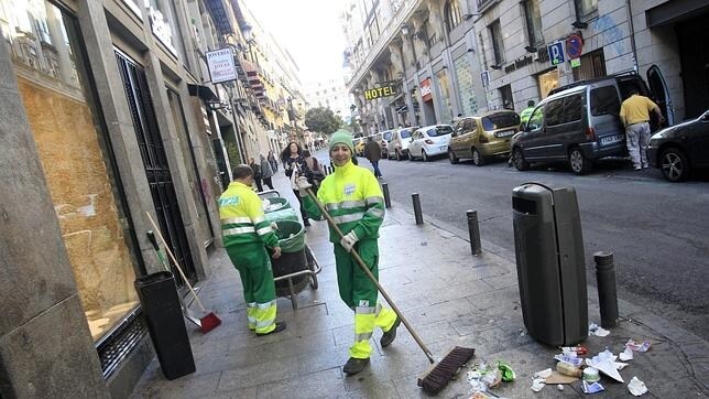 En la imagen, personal de limpieza limpia una calle en el centro de Madrid