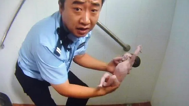 El momento en el que el policía consigue rescatar a la niña recién nacida
